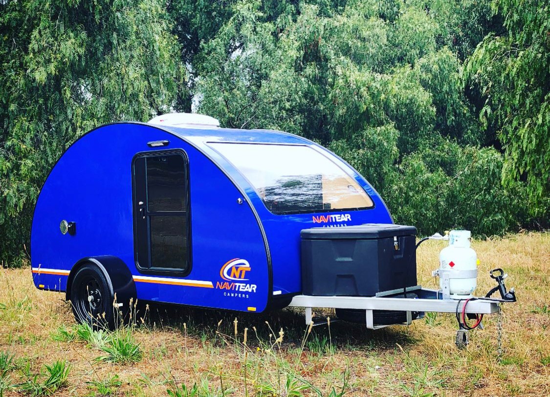 Blue Navitear teardrop camper in a green field