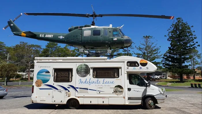 Motorhome parked in front of display US Army helicopter