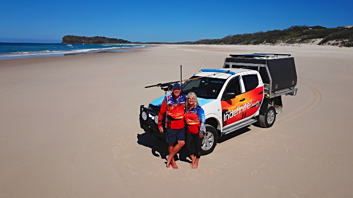 Couple standing in front of their ute on Fraser Island