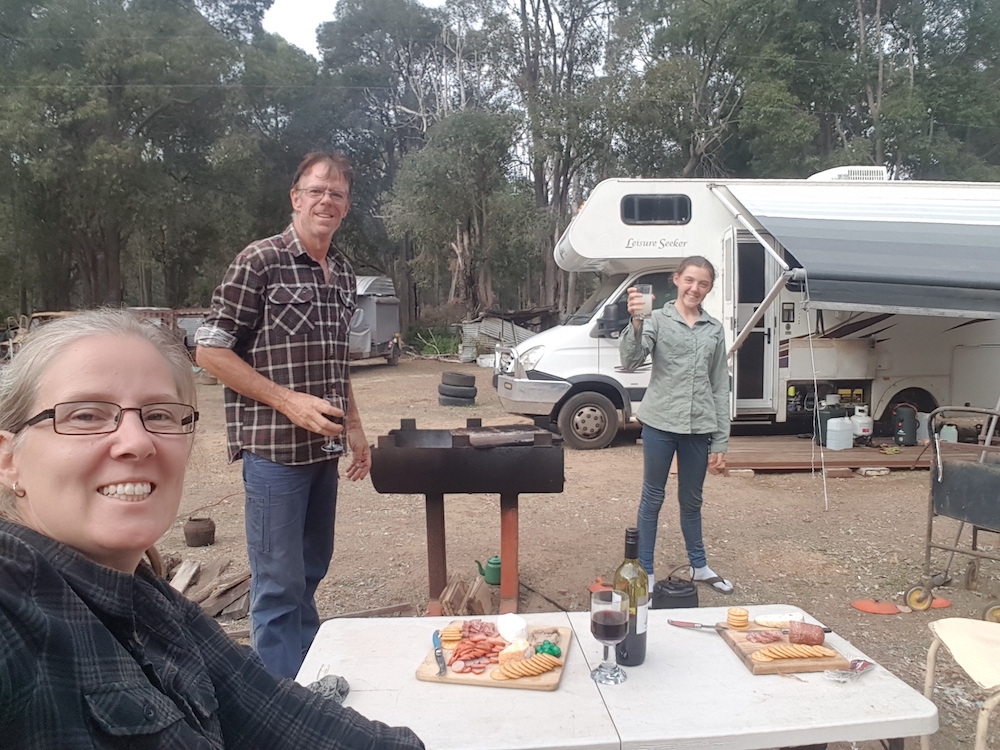 Mum, dad and child having a picnic outside their motorhome in Australia.