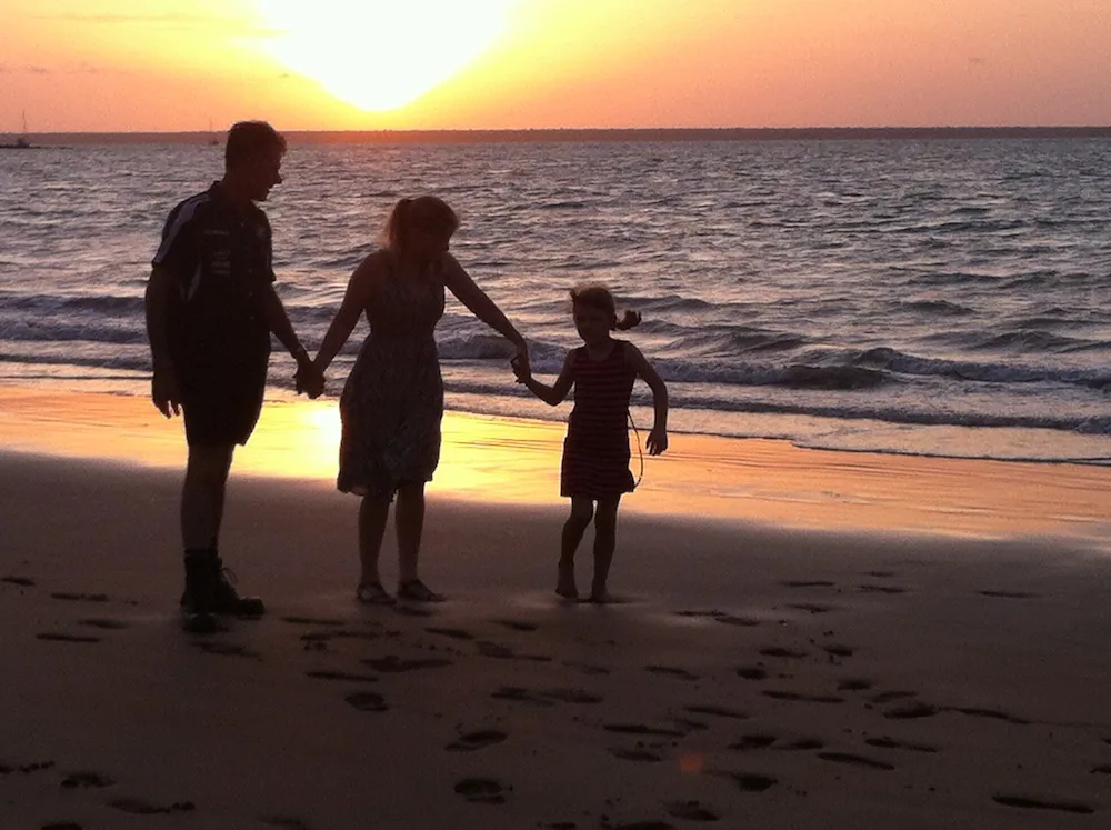 Family walking along the beach at sunset
