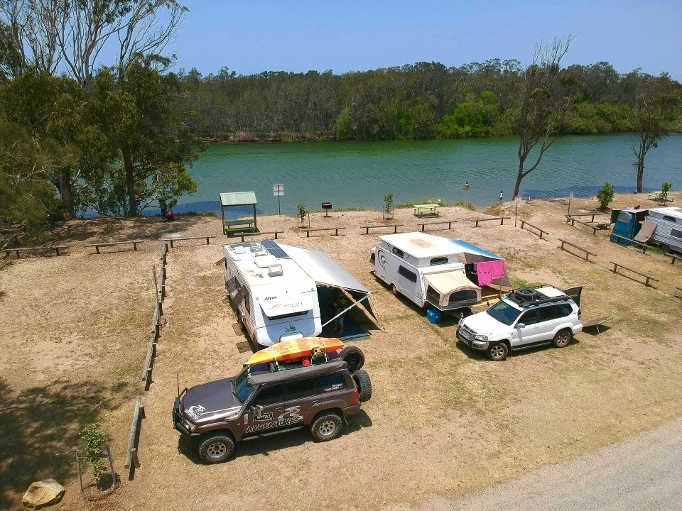 Aerial view of two caravans camped beside a river