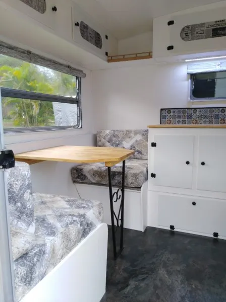 Interior of a renovated caravan, showing the dinette area.