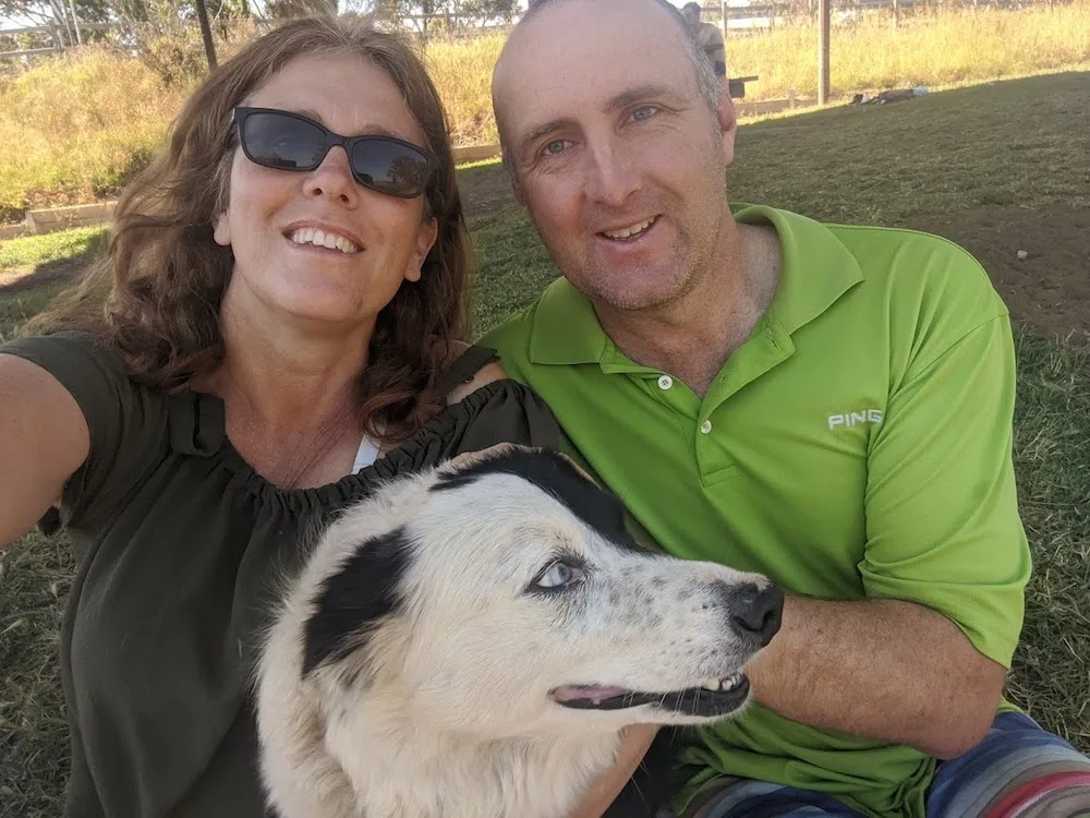 Couple pose for a photo with their Border Collie