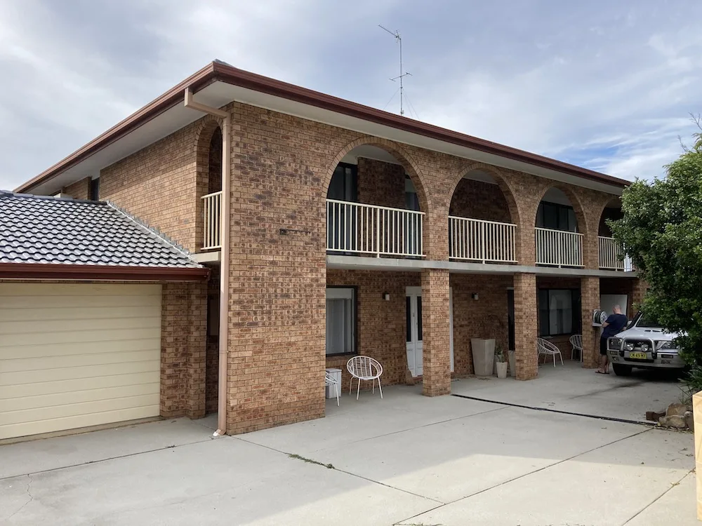 Two storey brick house with balcony on the second level