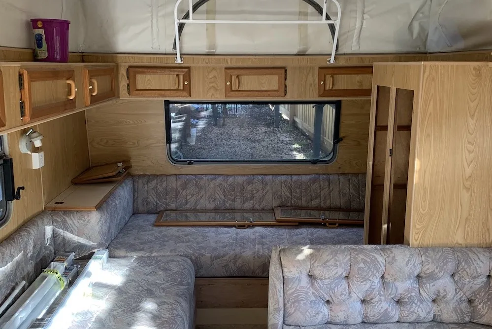Interior of a vintage van with brown walls and lilac upholstery