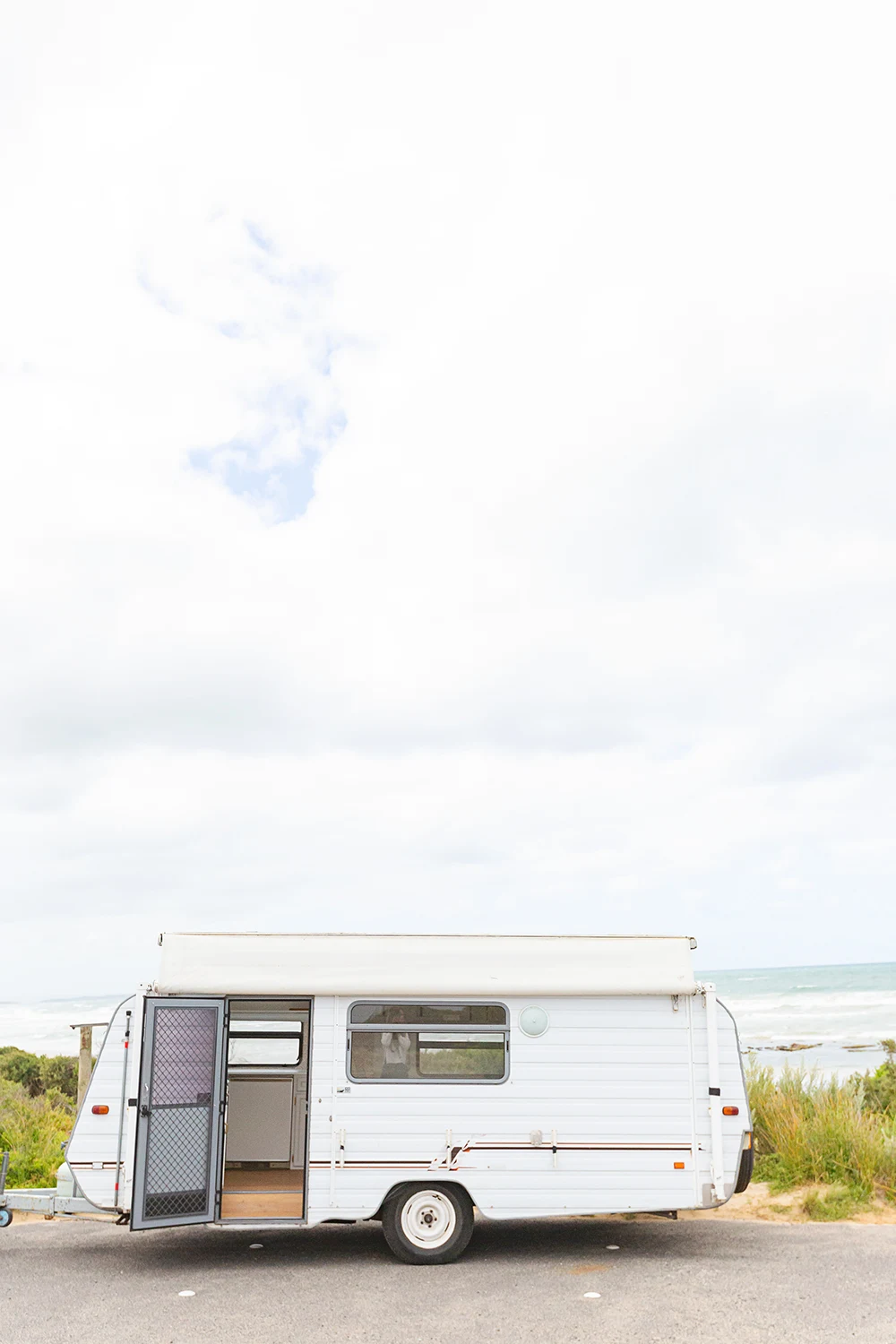 Vintage pop top caravan parked at a beach location