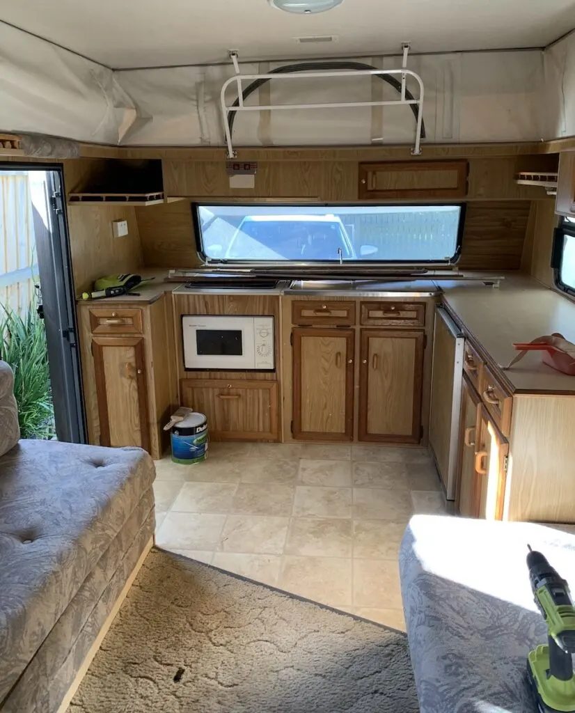 Brown kitchen cabinets inside a vintage pop-top caravan