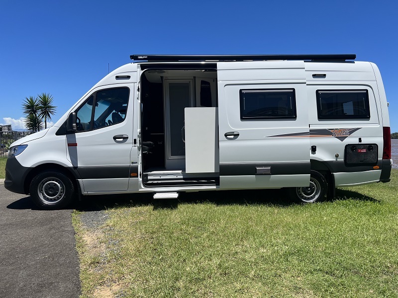 Side view of a white Horizon Motorhomes Wattle campervan with the side door open.