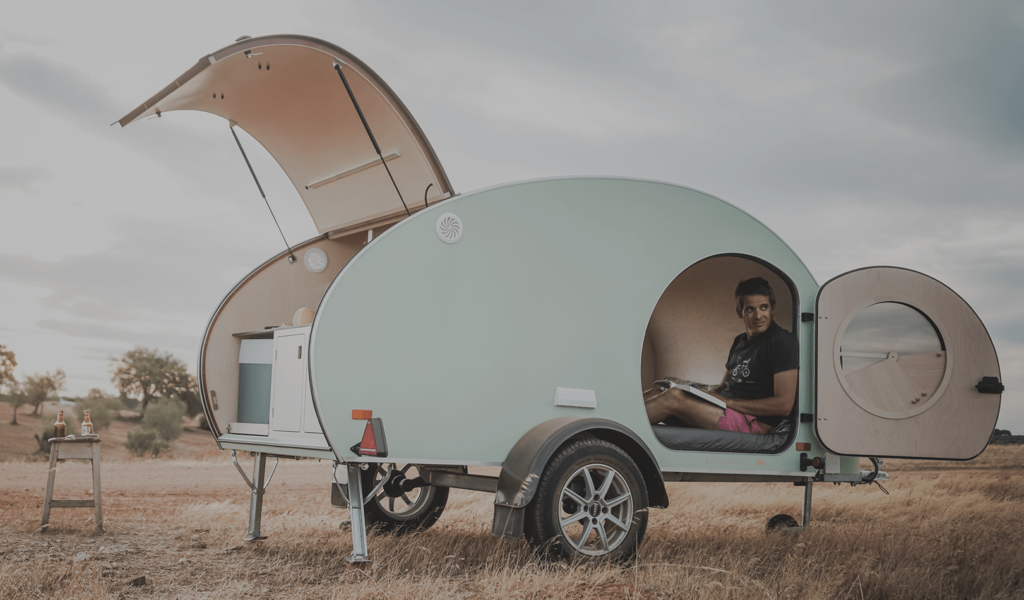 Pale green retro style teardrop camper with side and rear doors open.