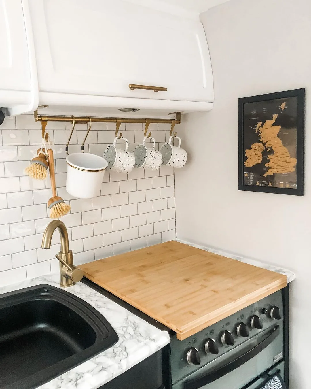Caravan kitchen with a butchers block cover on the stove top.