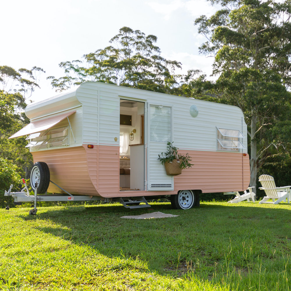 Exterior of a renovated caravan with pink and white body paint.