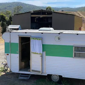 Exterior of vintage caravan with green and white paint work.