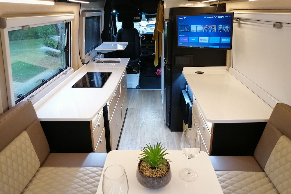 Interior of a Kimberley Kampers Kruiswagen campervan showing the kitchen and seating area, looking from the back towards the front of the van.