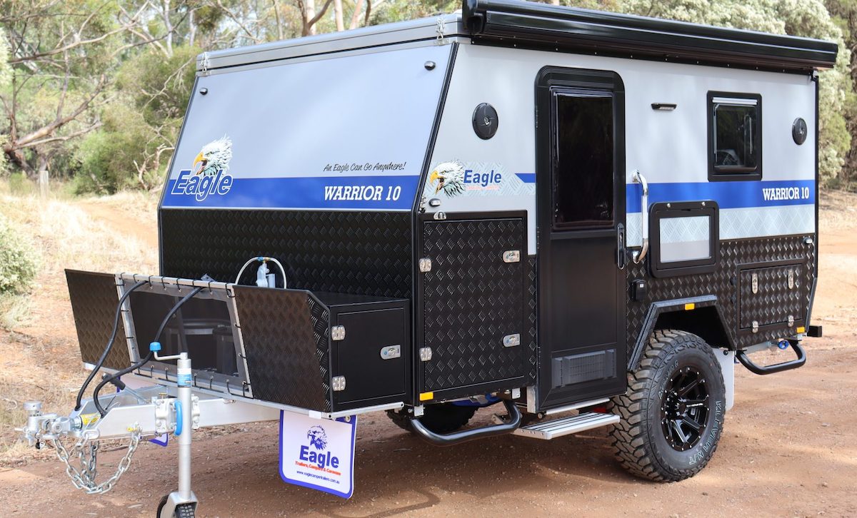 Exterior of a Eagle Campers Warrior 10 hybrid camper showing the awning, kitchen slide and bed extension out.